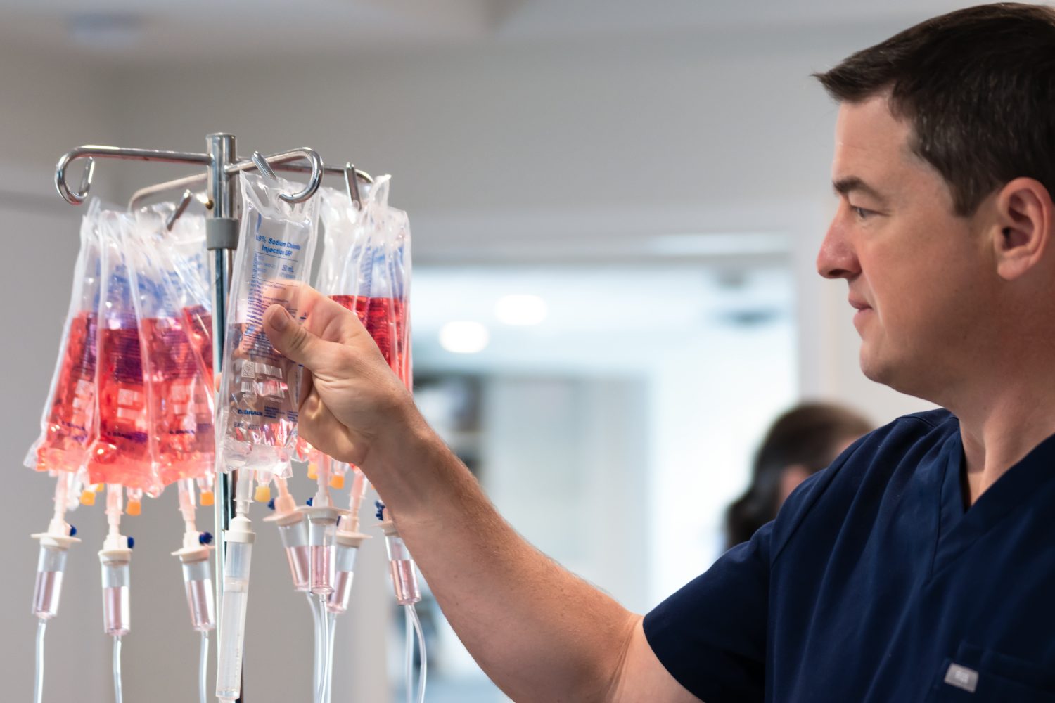 A YNC team member checks a row of prepared IV bags