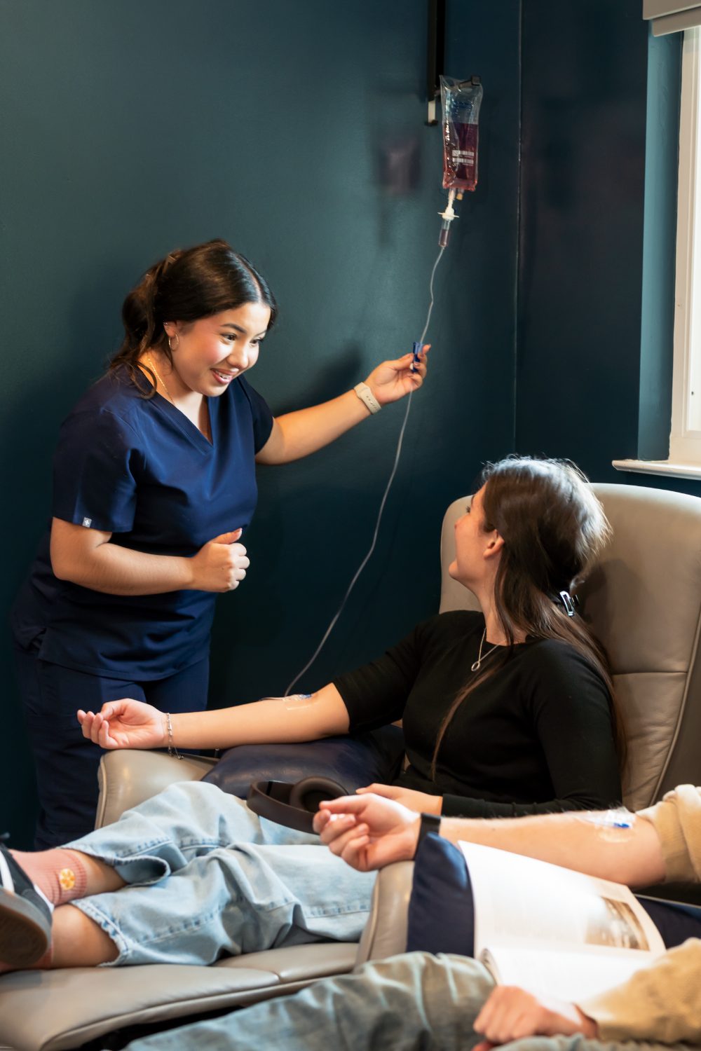 A YNC nurse adjusts a patient’s IV line
