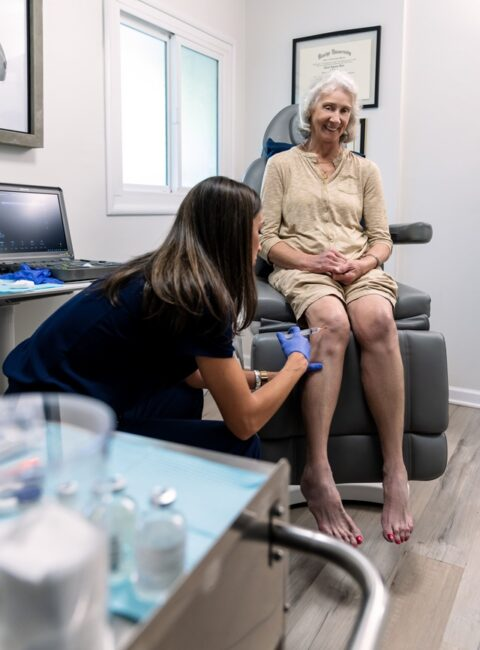 A YNC clinician gives a knee treatment to a seated patient